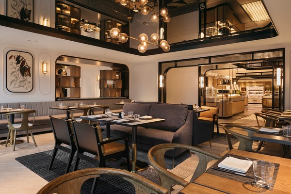 Elegant restaurant interior with various seating arrangements, illuminated by spherical lights. The open kitchen and framed artwork add to the sophisticated ambiance.